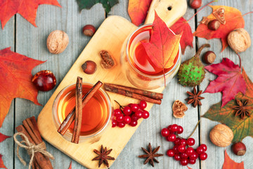 Autumn hot beverage in a glass with fruits and spices