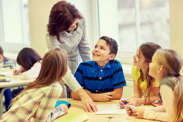 group of school kids writing test in classroom