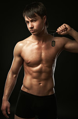 The muscular young  sexy man on black background