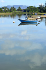 An unrecognized fisherman in a lonely wooden fishing Boat on a c