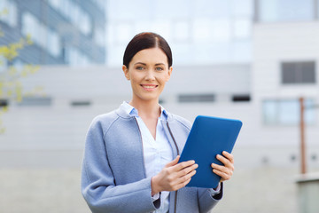 smiling business woman with tablet pc in city