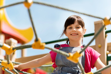 happy little girl climbing on children playground