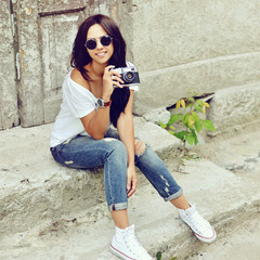 Beautiful young woman posing with old fashion camera