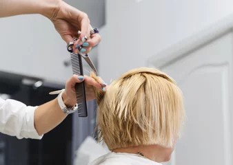 Crédence de cuisine en verre imprimé Salon de coiffure Coiffeur coupant les cheveux blonds