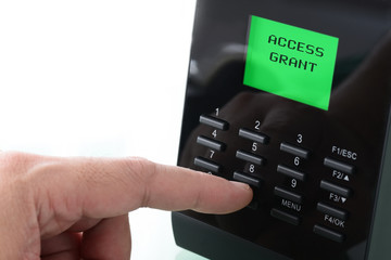 Closeup of finger pressed on access control and get access grant. Isolated in white background