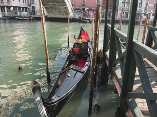 Fototapeta na wymiar Gondola moored by quay on Venice canal, Italy