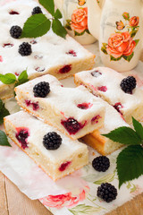 Cake cake with fresh blackberries on a wooden table