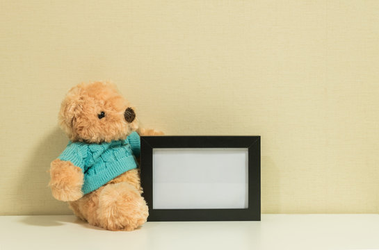 Frame for a photo with brown bear doll on wall room background