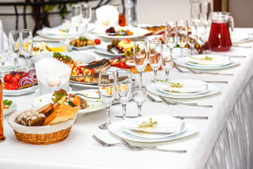Served banquet table with plates, glasses and dishes