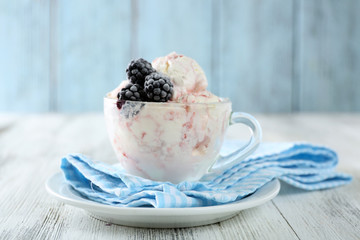 Delicious ice cream with fresh frozen berries, on color wooden background