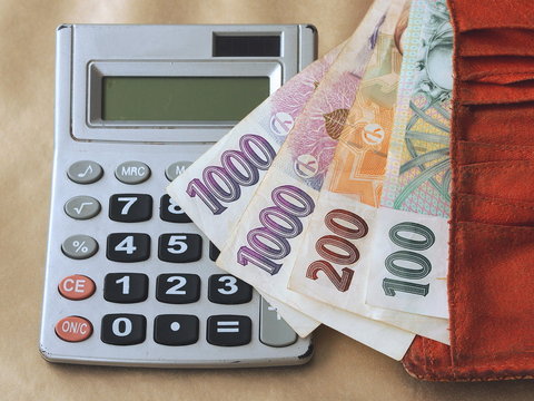 Counting money - Czech banknotes in a wallet and a personal calculator.