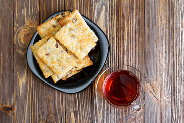 Cookies with raisins and cup of tea on the dark wooden table
