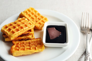 Sweet homemade waffles on plate, on light background