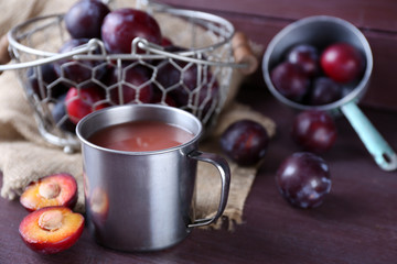 Delicious plum juice with fruits on table close up