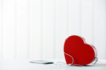 headphones with heart and phone on white background