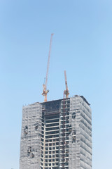 Fototapeta na wymiar Crane working on a building under construction.