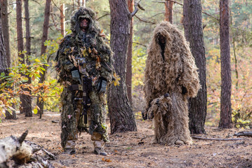 Two snipers in the forest/Two sniper in camouflage suits stands in the forest with rifles © nesterenko_max