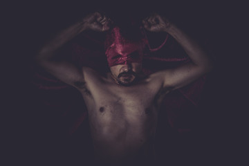Fototapeta na wymiar Paranormal, naked man on large red cloth over his eyes