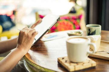Obraz na płótnie Canvas Woman using a tablet during a coffee break