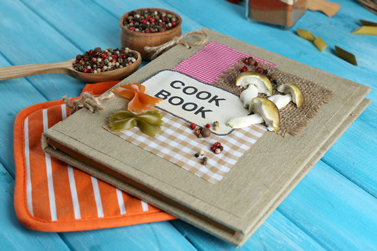 decorated cookbook on blue wooden background