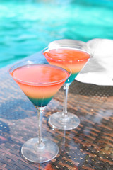 Cocktails on swimming pool background