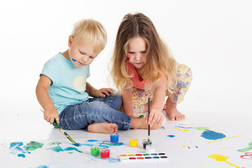 Childs are drawing pictures by aquarelle paints