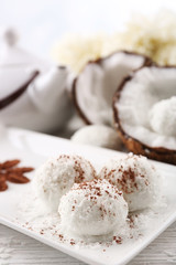 Homemade coco sweets on plate, on light background