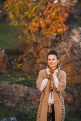 Relaxed brunette woman walking in beautiful evening autumn park