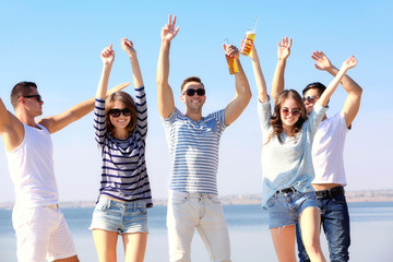 Fototapeta premium Young people with beer on the riverside