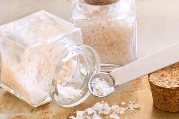 Sea salt closeup with glass jars and cork lids