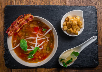 Vegetable soup served with crisp bacon, cheese and croquettes