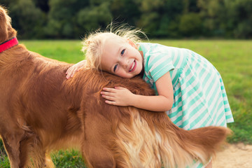 Adorable little blond girl hugging her cute pet dog