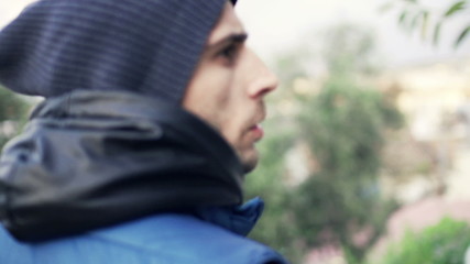 Young, afraid man looking around in park, slow motion 120fps
 - Powered by Adobe