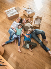 a family laying in their new flat with cardboard boxes
