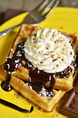 Homemade waffles with chocolate and whipped cream.