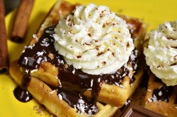 Homemade waffles with chocolate and whipped cream.