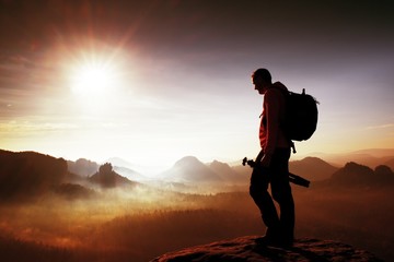 Silhouette des Fotografen mit Blick auf eine Nebeldecke über dem Tal zur Sonne