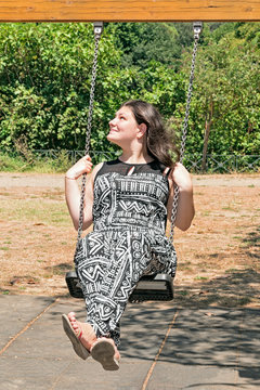 brunette girl on swing in park