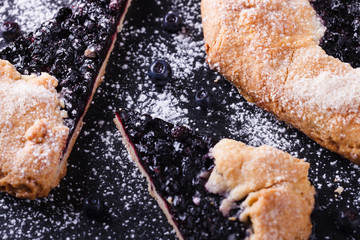 Galette with blueberries  on a black background.