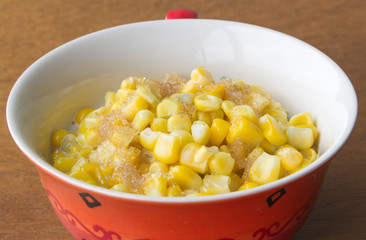 Sweet corn soup with sugar and milk on wooden background