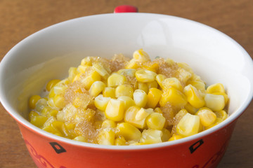 Sweet corn soup with sugar and milk on wooden background