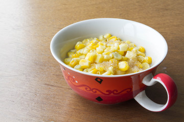 Sweet corn soup with sugar and milk on wooden background