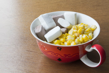Sweet corn soup with Marshmallows and milk on wooden background