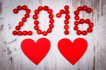 New year 2016 made of red viburnum and red wooden hearts on old wooden background