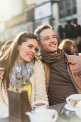Trendy couple having fun and sitting at a terrace in the city.
