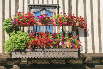 Fototapeta na wymiar beautiful balcony decorated with red geraniums