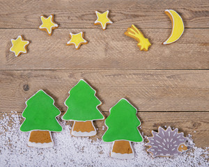 Christmas card with colorful gingerbread on a natural wooden background 