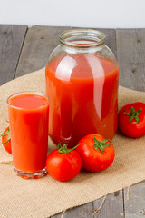 Tomato juice in glass and two-liter jar