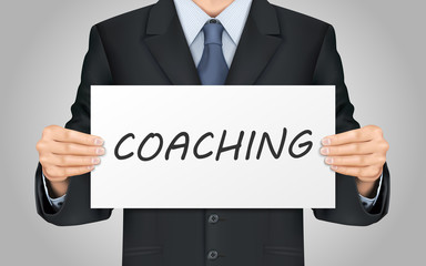 businessman holding coaching poster