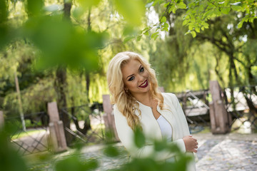 Naklejka premium Portrait beautiful smiling young woman in green summer city park